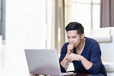 Image of young woman using her laptop at home